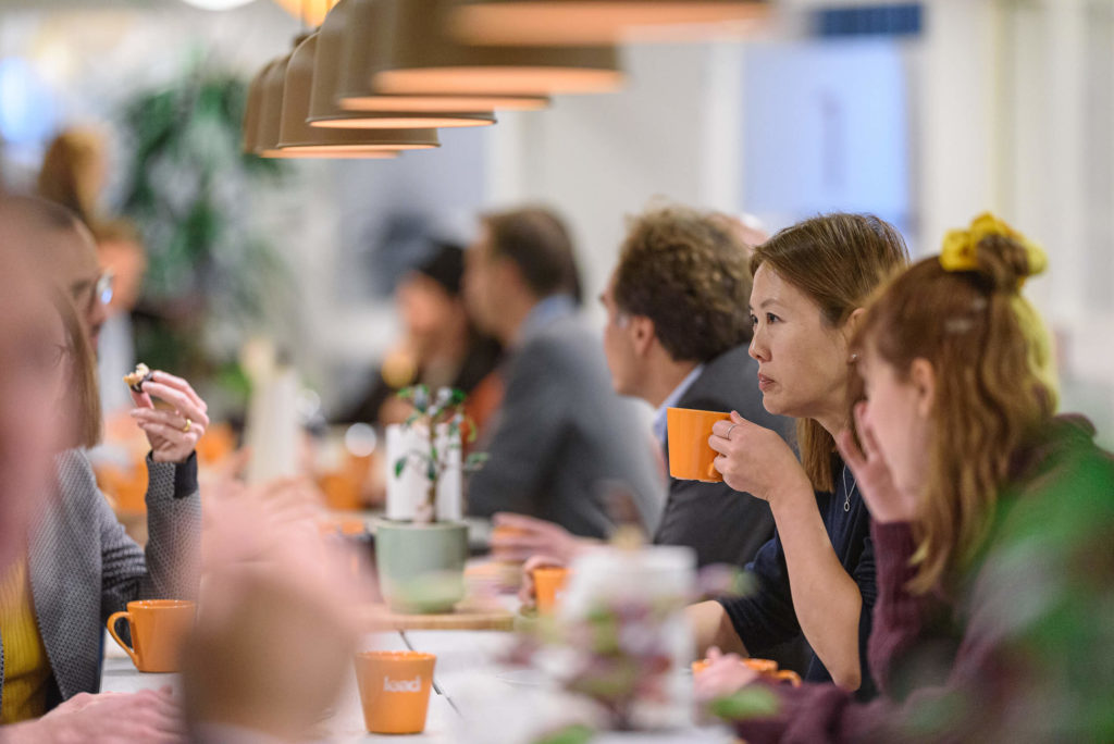 Personer sitter vid bort och dricker kaffe och pratar